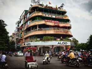 Photo by Jörg Faißt: bustling Hanoi scene with motorcycles and cafés.