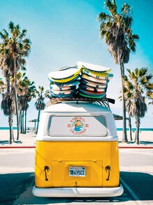 Wall art featuring a yellow VW bus surrounded by palm trees under a blue sky.