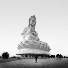 Big Buddha in Chiang Rai, a calming sight with blue sky and lush greenery.
