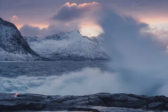 Waves crash on the Norwegian coast at sunset, featuring calm pastel colors.
