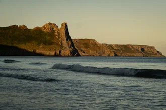 Photo art: coastline in Pembrokeshire, Wales with gentle waves and a calm sky.