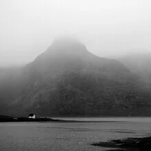 House by the lake in Norway, surrounded by mountains and fog