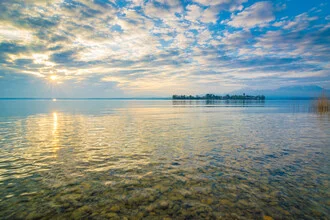 Fotografie von Martin Wasilewski: Chiemsee bei Sonnenaufgang mit Bergen im Hintergrund.