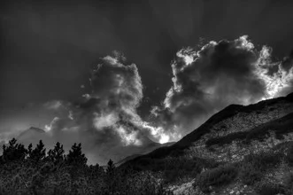 Fotokunst von Björn Groß: Stadelhorn mit Wolken über den Alpen und Bäumen im Vordergrund.