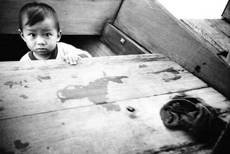Vietnamesischer Junge im Boot, friedliche Atmosphäre auf dem Wasser.
