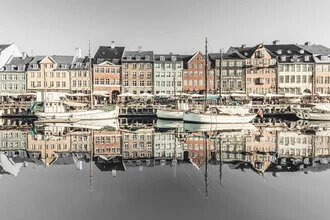 Water reflection in Copenhagen's harbor with colorful houses in the morning.