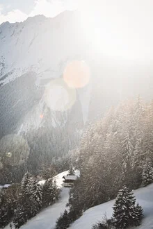 Photo art by Lotte Wildiers: mountain cabin surrounded by snow-covered peaks at sunset