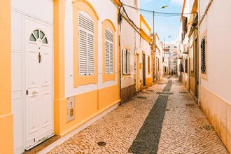 Urban scene in Olhão: yellow and white buildings on a sunny street