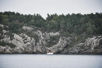 Photo art by Lotte Wildiers: serene coastal landscape with a boat and cliffs