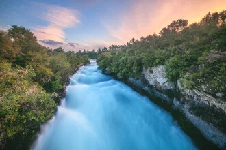 Wunderschöner Wasserfall in Neuseeland, umgeben von üppigem Grün und fließendem Wasser.