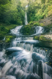 Photo of McLean Falls in the Catlins, New Zealand, surrounded by lush greenery.