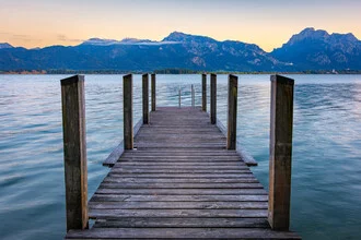 Sunset at Lake Forggensee with mountains in the background and calm water.