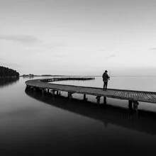 Photo art of a solitary fisher on a jetty in black and white