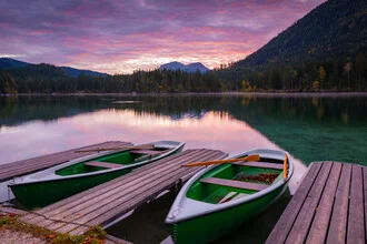 Sunrise at the lake with mountains in the background and a jetty in the foreground.