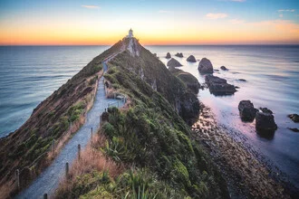 Morgendämmerung über dem Nugget Point Leuchtturm in Neuseeland mit sanften Lichttönen.