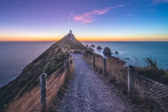 Wandbild von Jean Claude Castor: Leuchtturm bei blauer Stunde in Neuseeland.