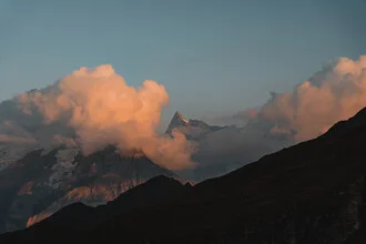 Clouds in warm colors above mountains at sunset