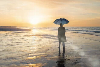 Photo art by Roswitha Schleicher-Schwarz: Man with hat, barefoot by the sea at sunset.