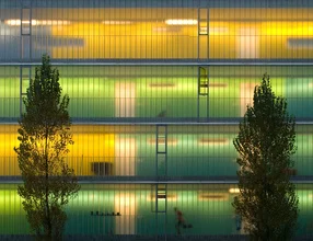 Photo art by Jochen Fischer: young people running by a colorful building