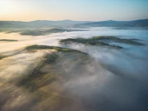 Morning misty landscape in Tuscany with gentle hills and a mysterious atmosphere.