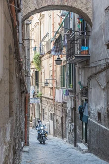 Photo art: A motorcyclist drives through the streets of Naples, capturing urban life.