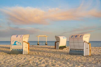 Schaukel im Meer bei Heiligenhafen mit Strand und Strandkörben im Hintergrund.