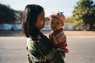 Photo art by Jim Delcid: mother with child in the serene landscape of Bagan, Myanmar.
