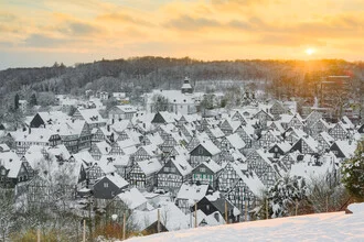 Winter scene in Freudenberg: half-timbered houses in snow at sunset.