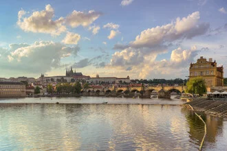 View of Prague Castle at sunset over the Vltava River.