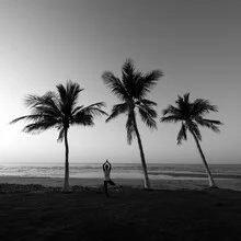 Photo art by Christian Janik: man in yoga pose on beach under palm trees