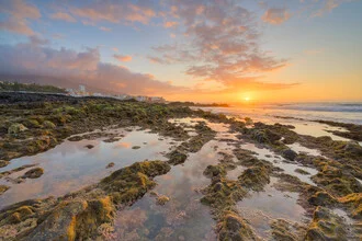Sunset over Playa Jardin with gentle waves and rocks