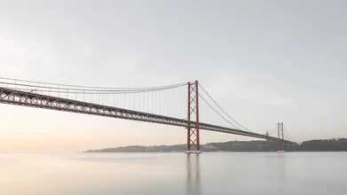 Soft sunrise colors over the Ponte 25 de Abril in Lisbon