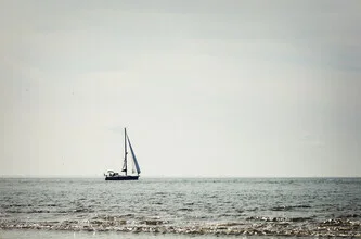 Photo art: A sailing boat alone on calm waters in front of a serene coastal landscape.