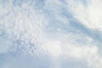 Photo of a cloudy sky featuring gentle, gray tones and a soft pattern.