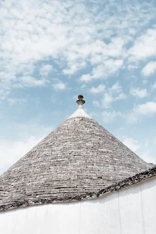 Dach eines traditionellen Trullos in Apulien, umgeben von einem blauen Himmel und Wolken
