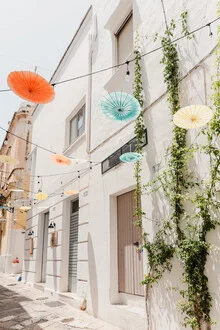 Street scene in Apulia featuring white buildings and an umbrella