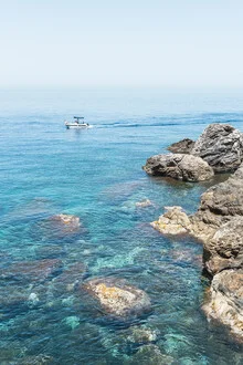 Fotokunst: Segelboot fährt entlang der italienischen Küste, umgeben von blauen Wellen.