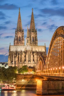 Illuminated Cologne Cathedral in the evening, creating a calm city atmosphere.