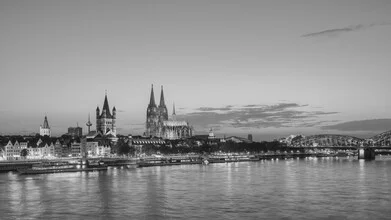 Black and white photo of the Cologne skyline at dusk with gentle light highlights.