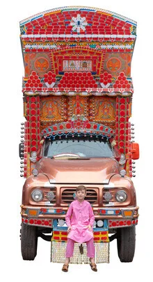 Fotokunst von Matthias Barth: ein Junge in pinker Kleidung vor einem bunten LKW in Pakistan.