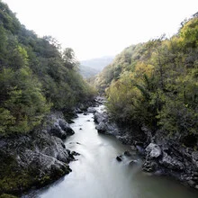 Fotokunst: Flusslandschaft in Montenegro am Morgen, umgeben von üppigem Grün.