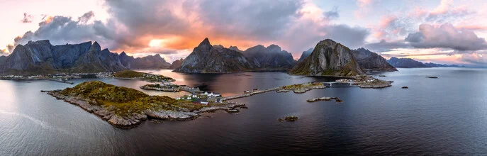 Panoramaaufnahme der Lofoten mit sanften Hügeln und einem ruhigen Meer bei Sonnenuntergang.