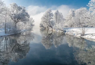 Frosty morning at Lake Kochelsee with gentle fog hovering over the water.