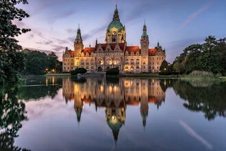 Illuminated Old Town Hall in Hannover, reflecting in the lake during the blue hour.