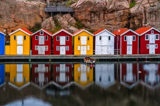 Colorful beach houses in Smoegen by the harbor with reflections in the water.