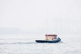 Boat in the Hamburg port, surrounded by fog and gentle water movements