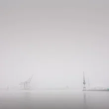 Photo art by Dennis Wehrmann: cranes in Hamburg harbor city during morning fog.