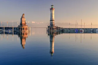 Harbour entrance in Lindau at Lake Constance with gentle mountains in the background.