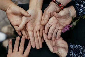 Photo art by Gloria Jansen: Four generations of strong women, hands showing connection.