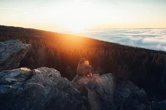 Couple above the sea of fog at sunset in the Harz mountains